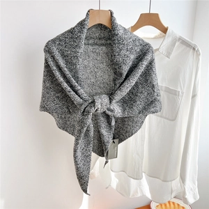 Close-up of thick grey melange knit wool shawl showing dense weave texture and soft fabric