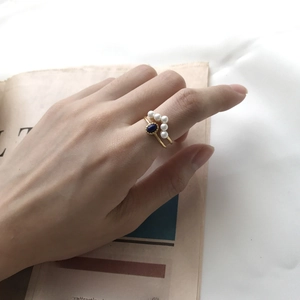 Detailed view of an S925 silver ring with white pearls and a deep blue gemstone