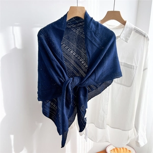 Close-up of navy blue hollow knit triangle shawl with geometric pattern on white shirt