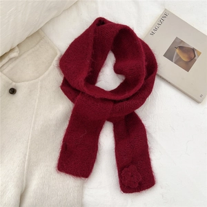 Detail view of wine red knit scarf showing soft mohair texture and 3D floral accent