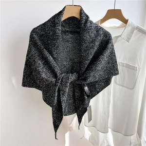 Close-up of black and white melange wool knit triangle shawl with front tie detail