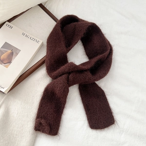 Close-up detail of soft dark brown knit scarf with fluffy mohair texture and warm feel