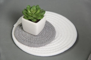 Close-up of hand-woven cotton rope heat-resistant coasters in white and grey colors