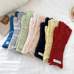 Flat lay of colorful knitted touchscreen gloves for women in eight soft winter hues