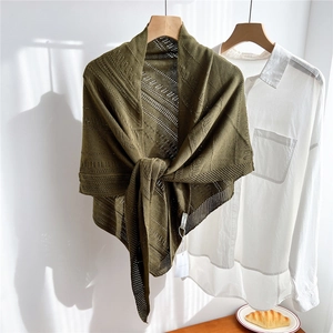 Detail of dark green hollow knit shawl showing delicate crochet texture and stripe patterns