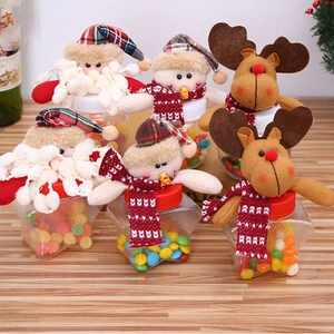 Dettaglio di barattoli natalizi per caramelle con figure in peluche e decorazioni festive