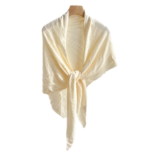 Elegant cream knitted triangle shawl with delicate hollow patterns hanging on wooden hanger