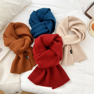 Sciarpa spessa in maglia di lana in rosso, blu navy e beige in un ambiente accogliente