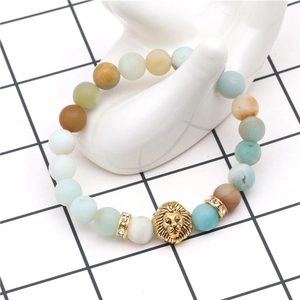 Macro detail of lion head charm with natural stone beads and crystal spacers