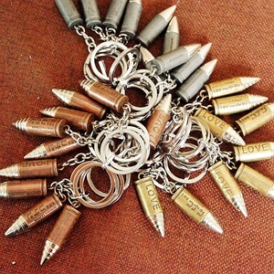 Detail of bullet-shaped metal keychains with Detective Conan engravings in vintage colors