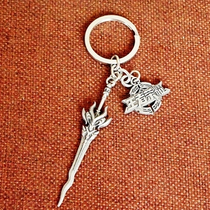 Detailed silver metal keychain featuring weapon sword and shield pendant with engraved logo