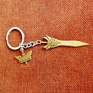 Detail shot of League of Legends sword keychain on vintage red fabric background