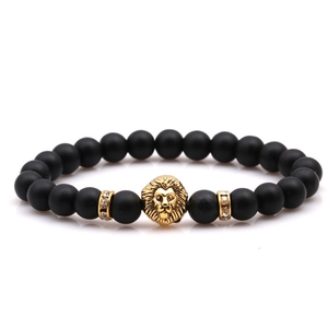 Macro detail of black matte beaded bracelet featuring a golden lion head and crystal rings