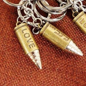 Macro detail of bronze and silver bullet keychain with custom engraved characters