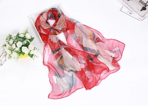 Detailed texture of lightweight red chiffon scarf with colorful abstract leaf patterns