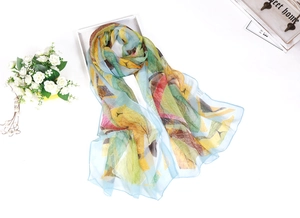 Flat lay of a lightweight chiffon long scarf with vibrant abstract leaf patterns in multiple colors