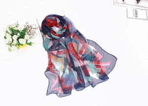 Artistic display of lightweight silk scarf with colorful geometric patterns and glitters