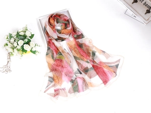 Flat lay of lightweight floral silk scarf with green leaf pattern on a white tray