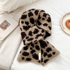 Dettaglio di sciarpa in maglia con stampa leopardata a rombi ed etichetta in tessuto