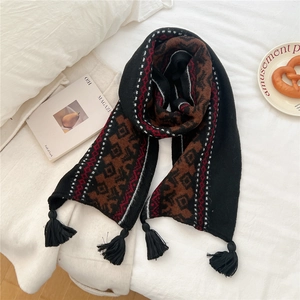 Detail shot of the vintage geometric jacquard knit scarf with thick black tassels