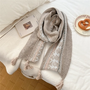 Detail of ethnic knit scarf showing snowflake patterns and soft fringe texture