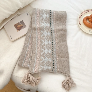Detailed view of jacquard winter scarf with snowflake patterns and soft fringe tassels