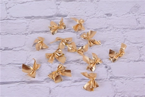 Golden metallic gift bows scattered on white texture for Christmas DIY craft decor