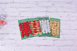 Close-up of four packs of Christmas ribbon bows in red, gold, silver, and dual-tone colors