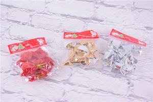 Close-up of red, gold and silver Christmas bows in transparent gift packaging with card