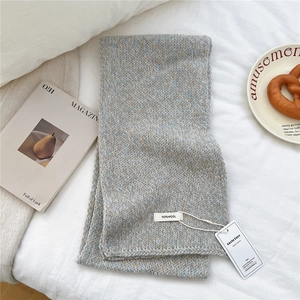 Close-up of 100% pure wool knitted scarf texture with grey-blue and beige mixed yarn