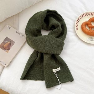 Detailed view of dark green wool scarf featuring high-quality 100% wool knit texture