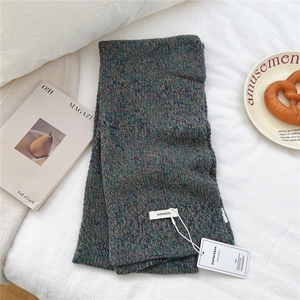 Detail of 100% pure wool knitted scarf showing multi-colored yarn texture and label