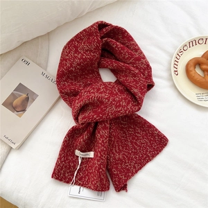 Detailed close-up of 100% wool knit scarf showing warm red knit texture and brand labels