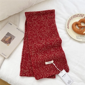 Detail of red and white mixed knit 100% wool scarf with authenticity tag and label