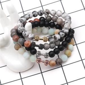 Detail of four lava stone dumbbell bracelets on hand model with cubic zirconia accents