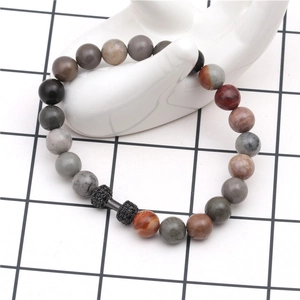 Detailed view of natural stone bead bracelet featuring a black dumbbell metal accessory