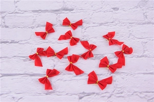 Detail of red fabric Christmas bows with gold ties for gift wrapping and DIY crafts