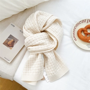 Close-up of 100% wool knit scarf featuring thick waffle texture and official quality tags
