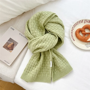 Detail of mint green wool scarf showing thick basket weave texture and ribbed knit hem