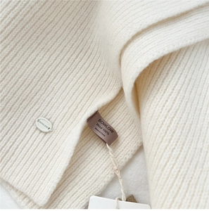 Close-up of premium 100% wool knitted scarf showing soft texture and brand labels