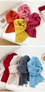 Detailed close-up of colorful ribbed knit wool scarves showcasing soft texture and tags