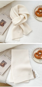 Macro view of cream wool knit scarf texture with metal tag and elegant brand label