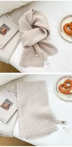 Close-up of beige ribbed knit wool scarf with metal logo tag and moth-proof cedar block