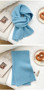 Detailed macro view of sky blue ribbed knit wool scarf with a product tag and cozy texture