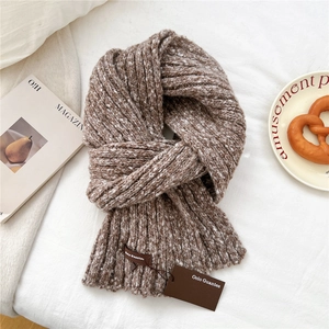 Macro detail of brown and white mixed knit scarf texture with luxury woven label