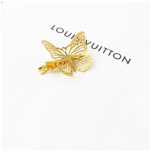 Detailed view of a golden hollow butterfly hair clip with fine filigree metal texture