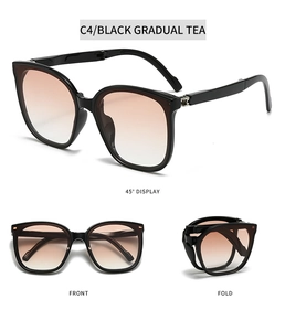 Detail of folding sunglasses with black frame and brown gradient lenses in compact form