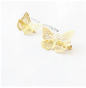 Detailed close-up of two gold hollow butterfly hair clips with elegant wing textures