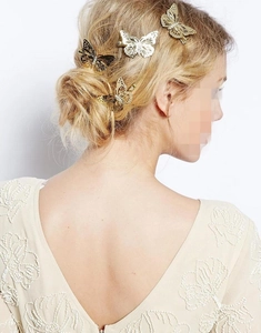 Detailed view of hollow butterfly hair clips set in gold and silver on model hair