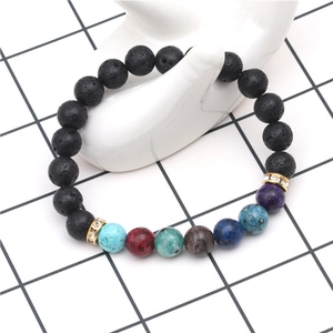 Pulsera de chakras en piedra de lava con siete cuentas de colores en mano de cerámica